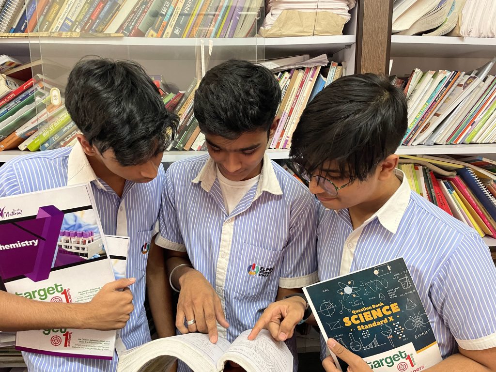 “Three students studying together with a book at Target 1 Academy Chinchwad”